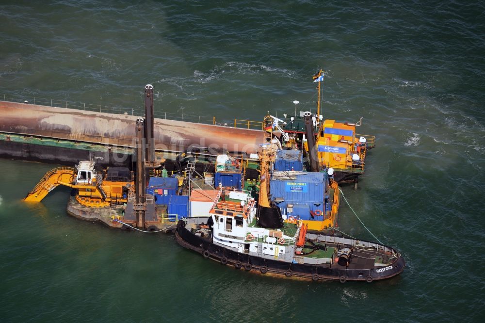 Warnemünde von oben - Ausbaggerungsarbeiten an einer Fahrstrecke - Fahrrinne und Sandaushub auf ein Frachtschiff- und Schüttgutfrachter auf der Wasseroberfläche der Ostsee in Warnemünde im Bundesland Mecklenburg-Vorpommern