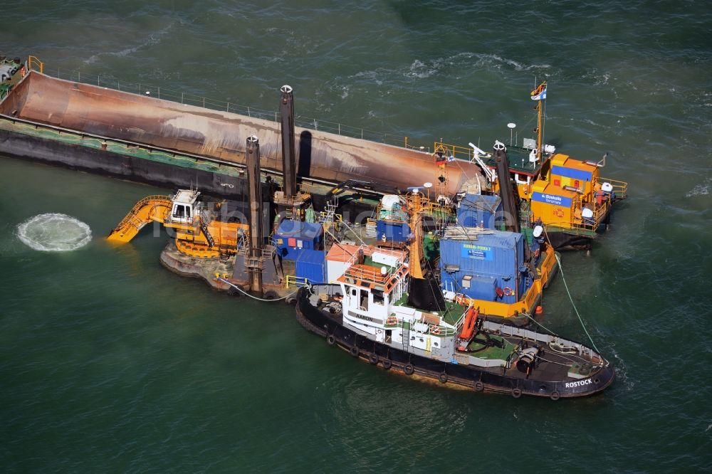 Luftbild Warnemünde - Ausbaggerungsarbeiten an einer Fahrstrecke - Fahrrinne und Sandaushub auf ein Frachtschiff- und Schüttgutfrachter auf der Wasseroberfläche der Ostsee in Warnemünde im Bundesland Mecklenburg-Vorpommern