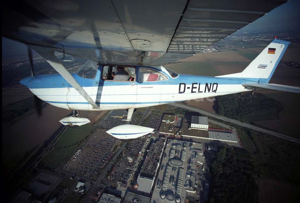 Günthersdorf aus der Vogelperspektive: Bannerschleppflugzeug Cessna 172 D-ELNQ über dem Einkaufszentrum nova eventis