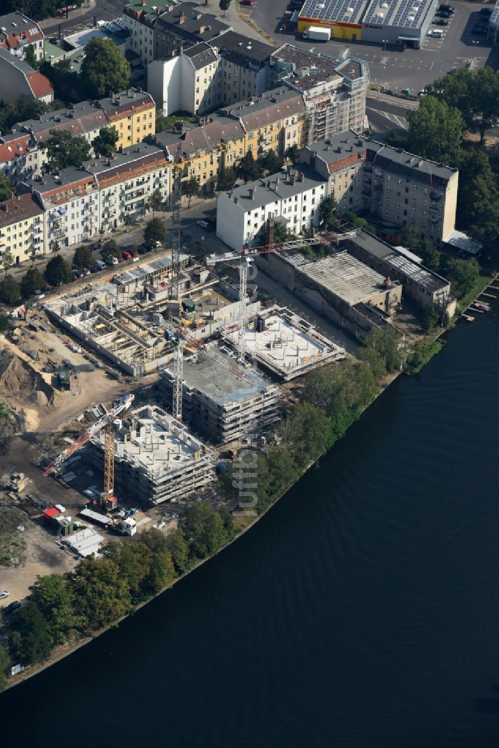 Berlin aus der Vogelperspektive: Baustelle zum Neubau einer Mehrfamilienhaus-Wohnanlage in der Tabbertstraße am Ufer des Flußverlaufes der Spree in Berlin