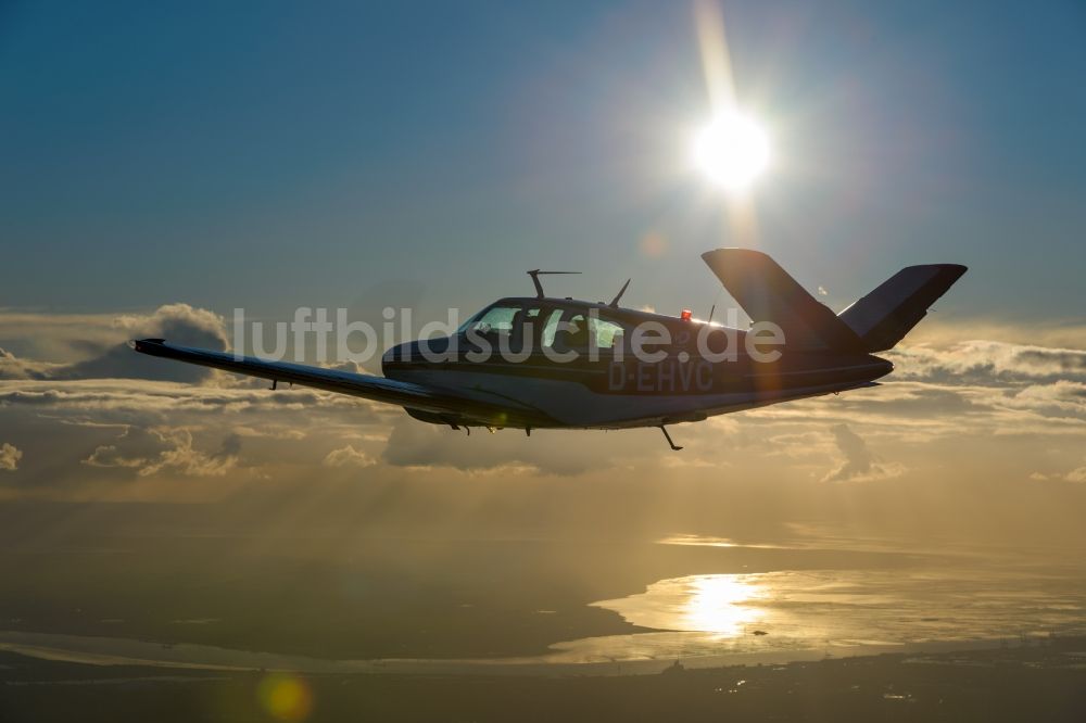 Bremerhaven aus der Vogelperspektive: Beechcraft Bonanza D-EHVC im Fluge über der der Wesermündung in die Nordsee bei Bremerhaven im Bundesland Bremen, Deutschland