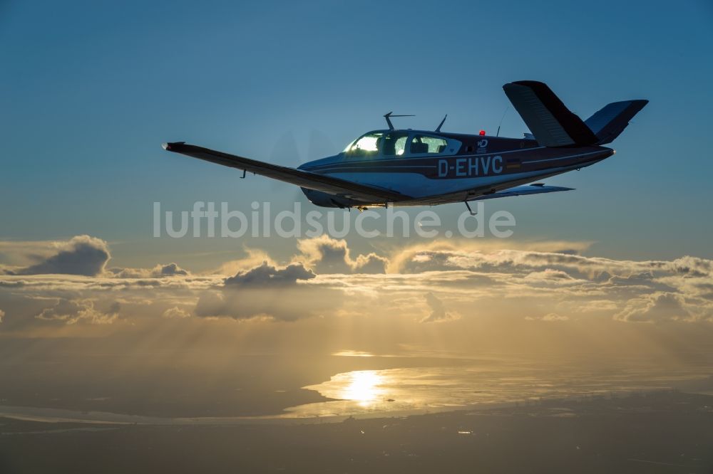 Luftbild Bremerhaven - Beechcraft Bonanza D-EHVC im Fluge über der der Wesermündung in die Nordsee bei Bremerhaven im Bundesland Bremen, Deutschland