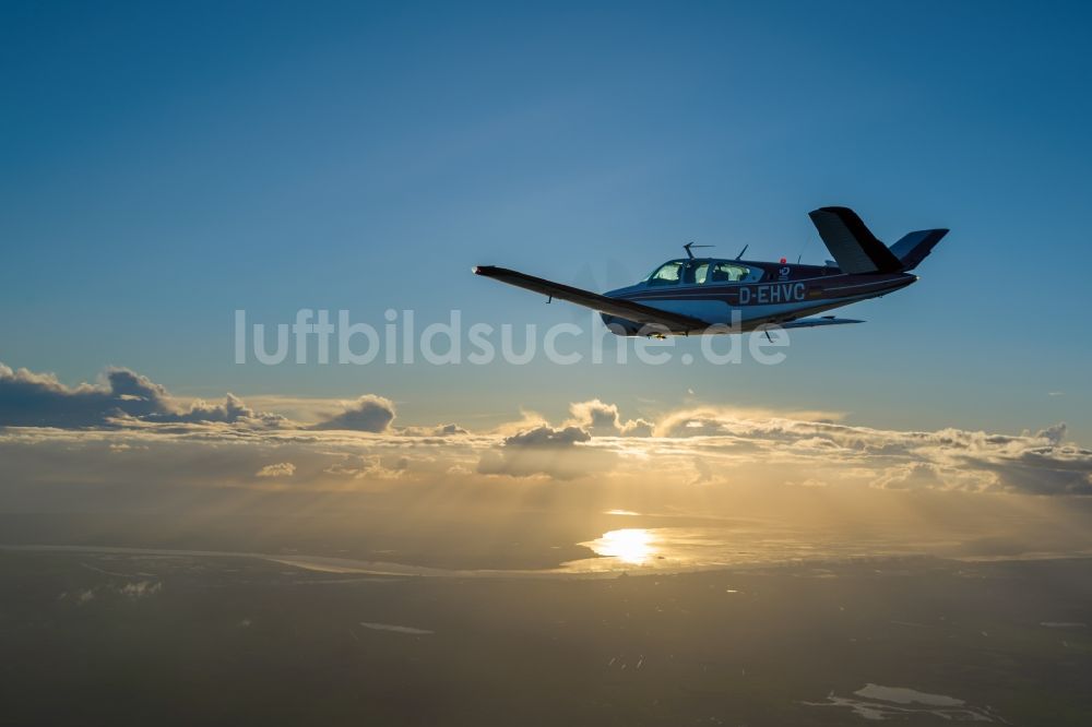 Luftaufnahme Bremerhaven - Beechcraft Bonanza D-EHVC im Fluge über der der Wesermündung in die Nordsee bei Bremerhaven im Bundesland Bremen, Deutschland