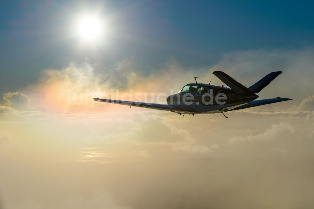 Bremerhaven von oben - Beechcraft Bonanza D-EHVC im Fluge über zwischen Wolken bei Bremerhaven im Bundesland Bremen, Deutschland