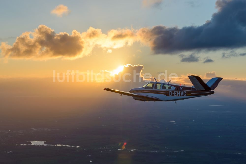 Geestland von oben - Beechcraft Bonanza D-EHVC im Fluge im Sonnenuntergang bei Geestland im Bundesland Bremen, Deutschland