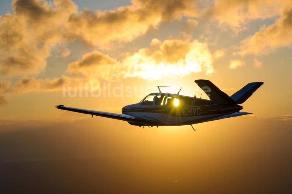 Luftbild Geestland - Beechcraft Bonanza D-EHVC im Fluge im Sonnenuntergang bei Geestland im Bundesland Bremen, Deutschland