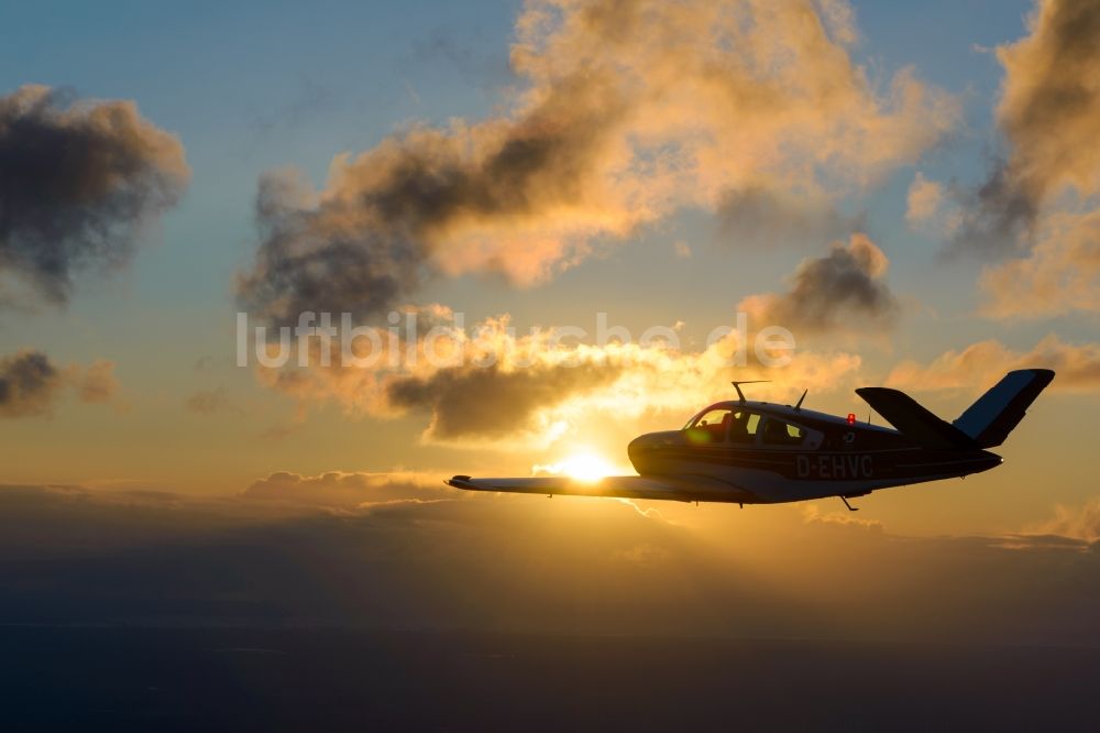 Luftaufnahme Geestland - Beechcraft Bonanza D-EHVC im Fluge im Sonnenuntergang bei Geestland im Bundesland Bremen, Deutschland