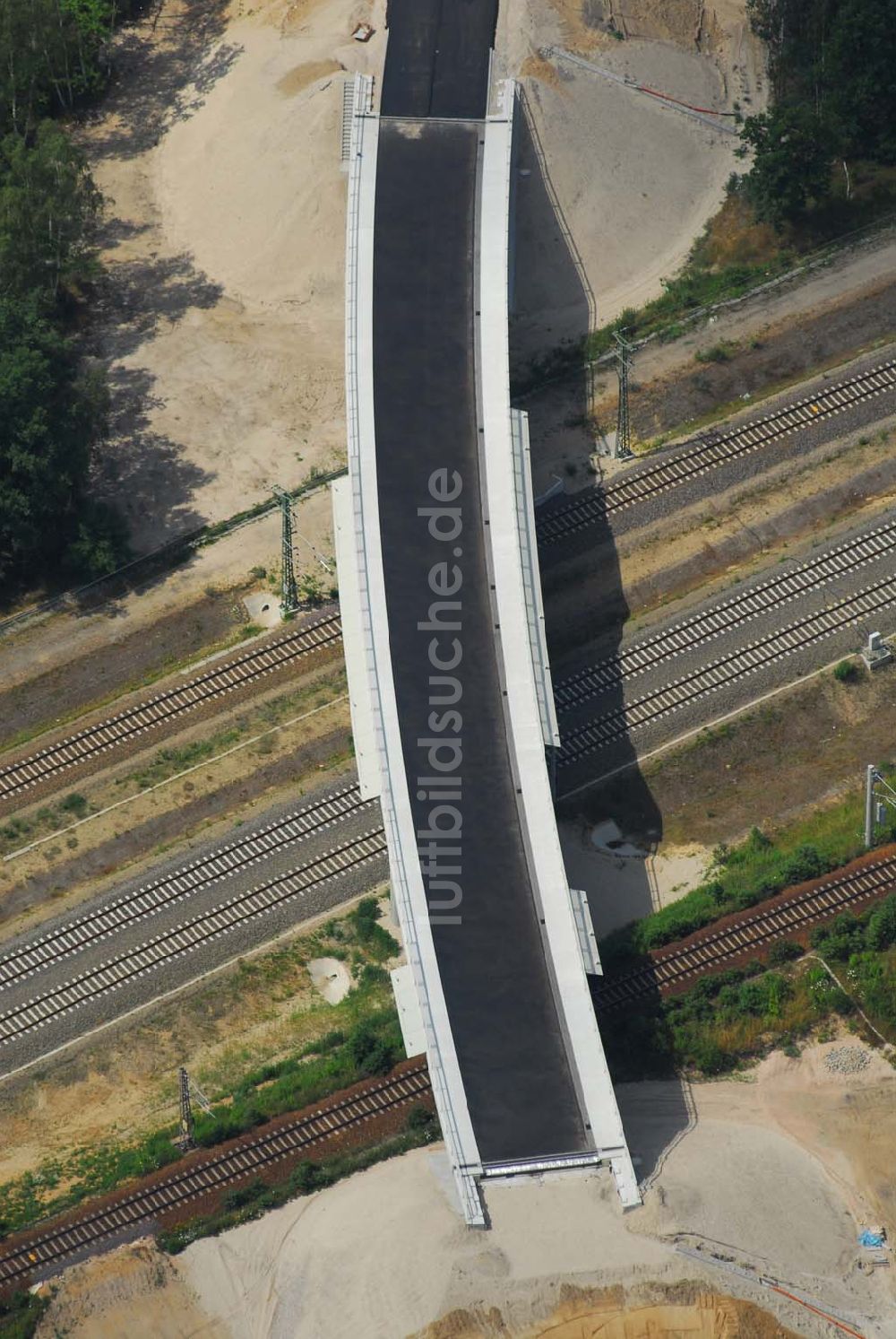 Luftaufnahme Ludwigsfelde - Blick auf eine Fußgängerbrücke über Gleisanlagen am Industriepark Ost in Ludwigsfelde bei Berlin, erbaut durch die Schälerbau Berlin GmbH