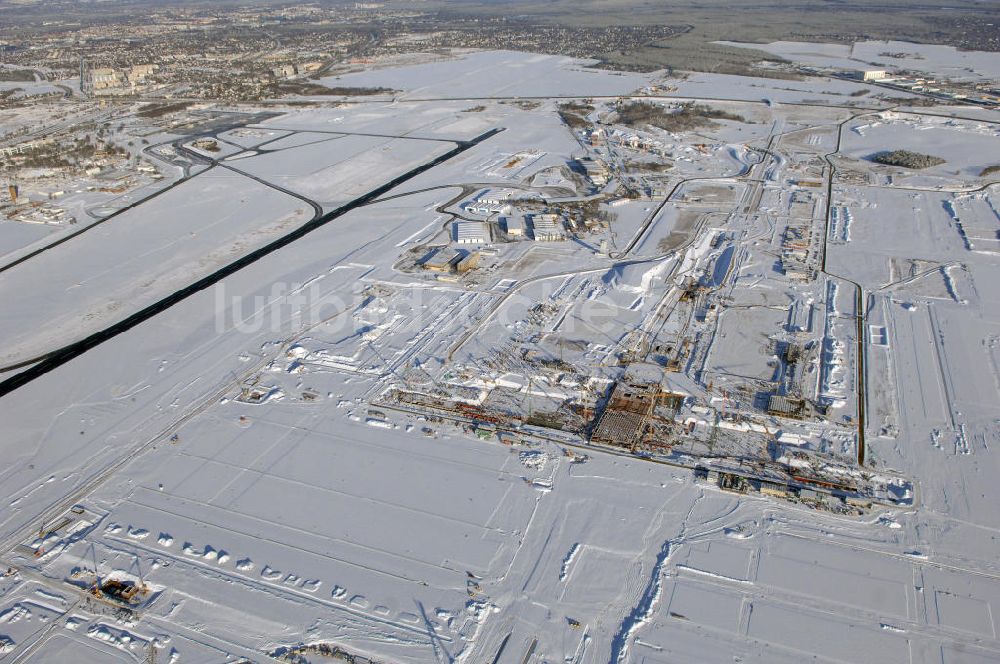 Luftaufnahme SCHÖNEFELD - Blick auf die winterlich verschneite Großbaustelle Neubau Bahnhof BBI am Flughafen Berlin-Schönefeld.