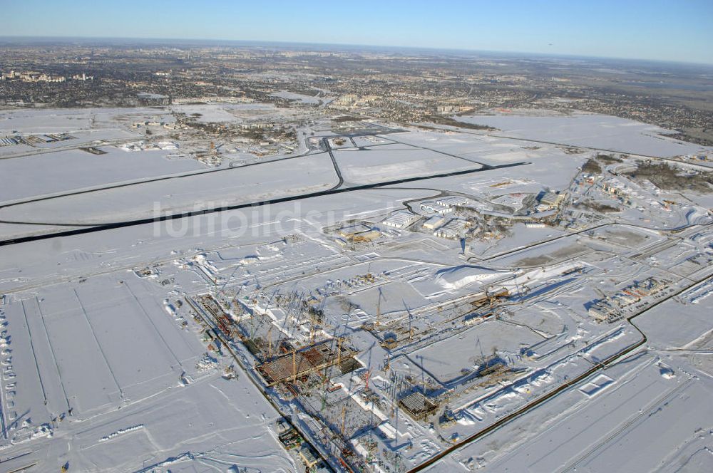 SCHÖNEFELD aus der Vogelperspektive: Blick auf die winterlich verschneite Großbaustelle Neubau Bahnhof BBI am Flughafen Berlin-Schönefeld.