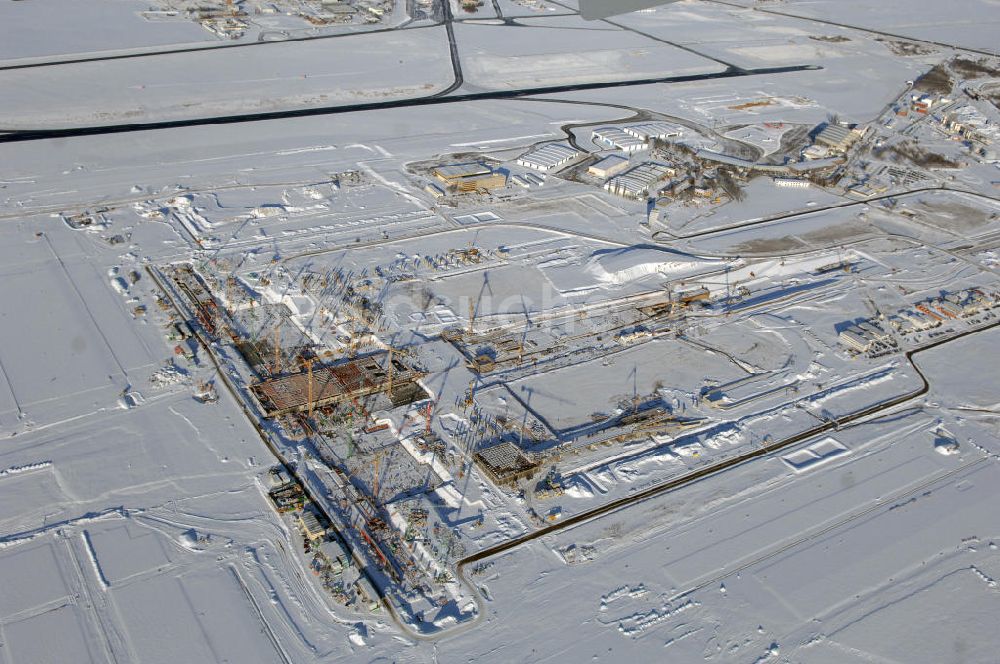 Luftbild SCHÖNEFELD - Blick auf die winterlich verschneite Großbaustelle Neubau Bahnhof BBI am Flughafen Berlin-Schönefeld.