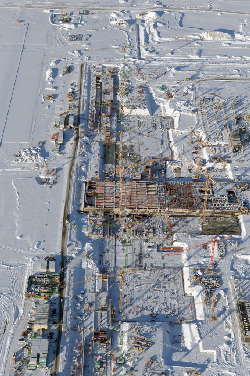 SCHÖNEFELD aus der Vogelperspektive: Blick auf die winterlich verschneite Großbaustelle Neubau Bahnhof BBI am Flughafen Berlin-Schönefeld.