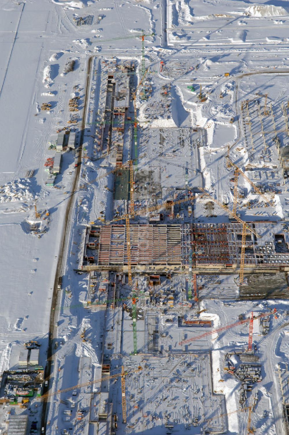 Luftbild SCHÖNEFELD - Blick auf die winterlich verschneite Großbaustelle Neubau Bahnhof BBI am Flughafen Berlin-Schönefeld.