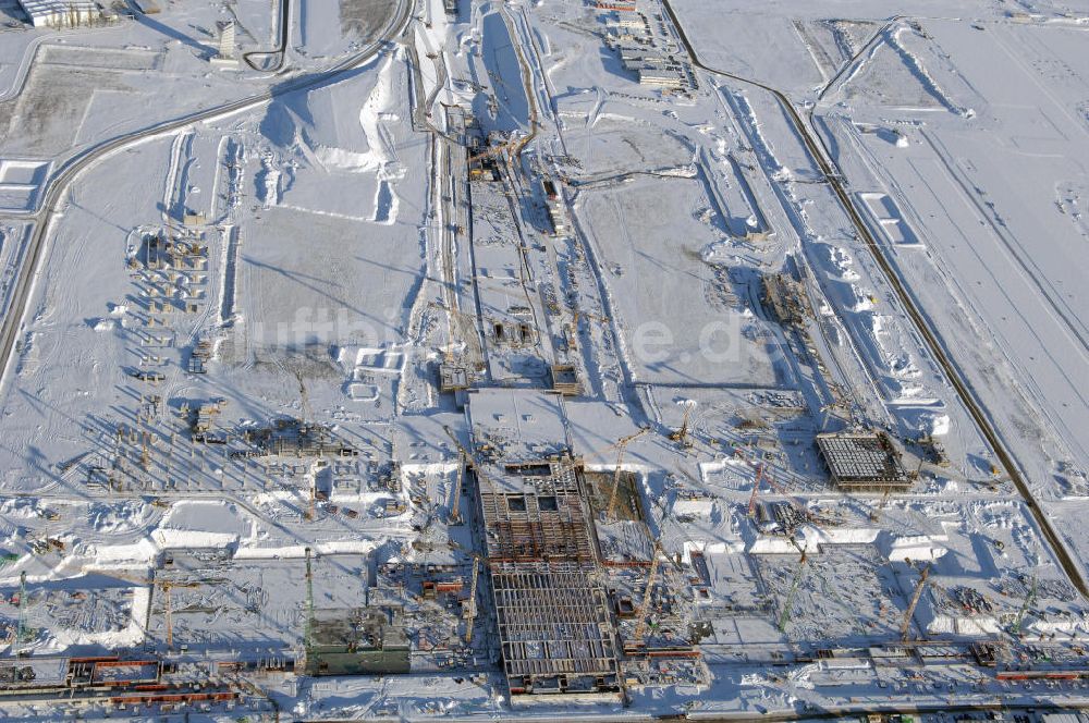 Luftaufnahme SCHÖNEFELD - Blick auf die winterlich verschneite Großbaustelle Neubau Bahnhof BBI am Flughafen Berlin-Schönefeld.