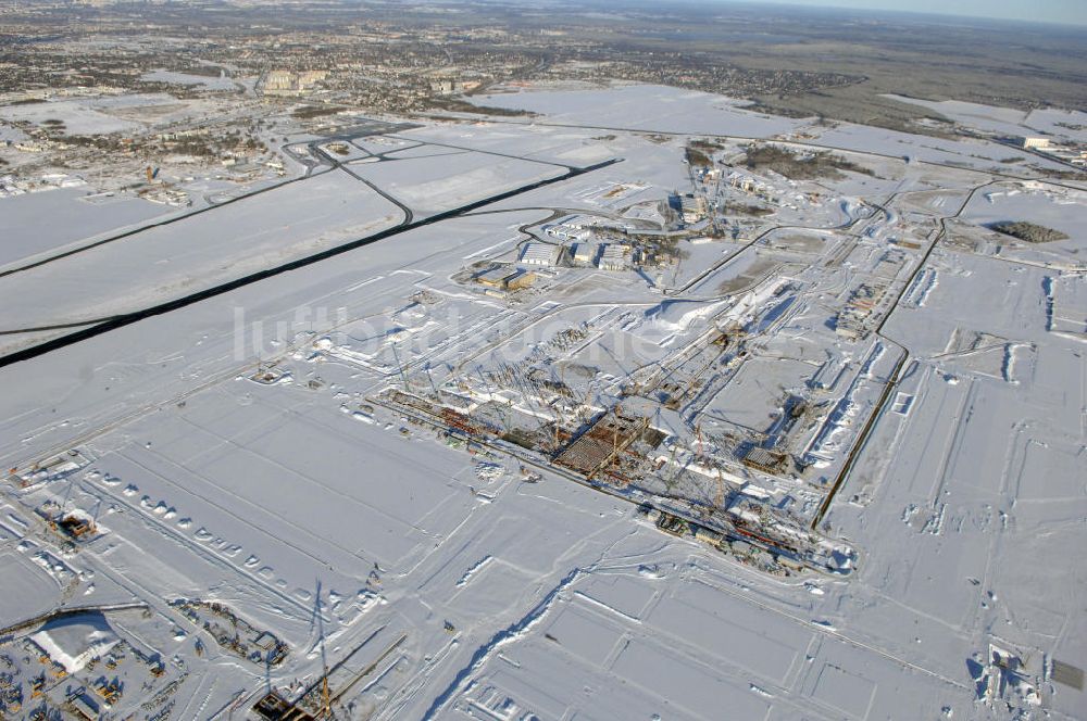 SCHÖNEFELD aus der Vogelperspektive: Blick auf die winterlich verschneite Großbaustelle Neubau Bahnhof BBI am Flughafen Berlin-Schönefeld.