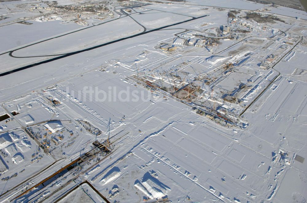 Luftaufnahme SCHÖNEFELD - Blick auf die winterlich verschneite Großbaustelle Neubau Bahnhof BBI am Flughafen Berlin-Schönefeld.