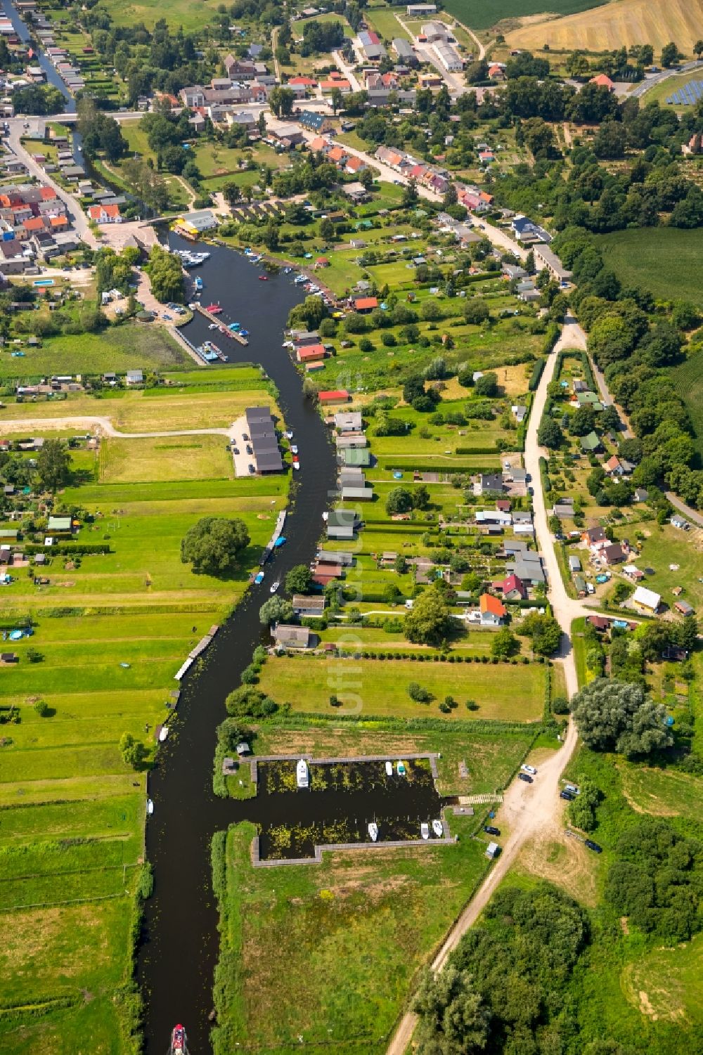 Luftbild Neukalen - Bootshaus- Reihen mit Sportboot- Anlegestellen und Bootsliegeplätzen am Uferbereich der Peene in Neukalen im Bundesland Mecklenburg-Vorpommern