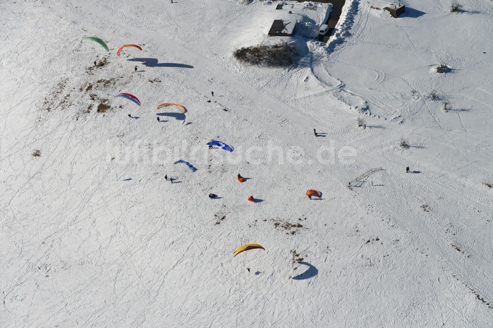 Schmiedefeld am Rennsteig von oben - Bunte Paraglider- Flieger an einem winterlich mit Schneebedeckten Hang in Schmiedefeld am Rennsteig im Bundesland Thüringen