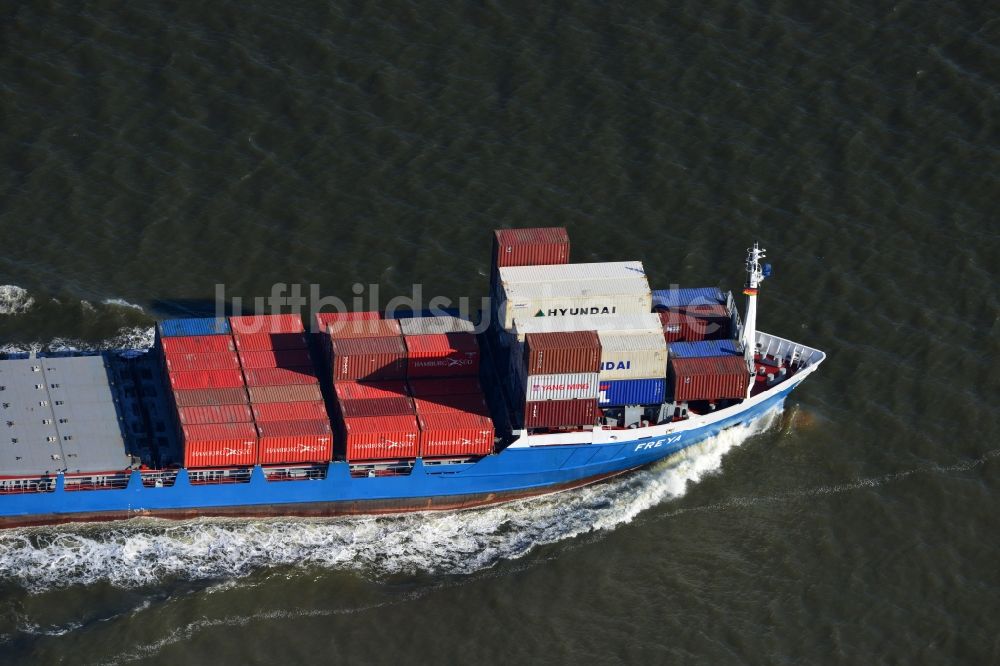 Cuxhaven aus der Vogelperspektive: Containerschiff - Frachter FREYA einer niederländischen Reederei bei der Fahrt vor der Nordseeküste bei Cuxhaven im Bundesland Niedersachsen