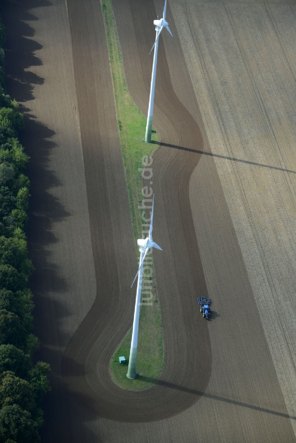 Kritzow aus der Vogelperspektive: Ernte- Traktor umfährt Windenergieanlagen (WEA) - Windrad und Strukturen auf einem Feld in Kritzow im Bundesland Mecklenburg-Vorpommern