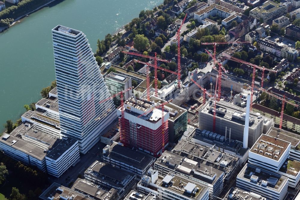 Luftaufnahme Basel - Erweiterungs- Baustellen und Baukräne am Areal und Betriebsgelände der Pharmafirma Roche mit dem Roche- Turm - Hochhaus in Basel in der Schweiz