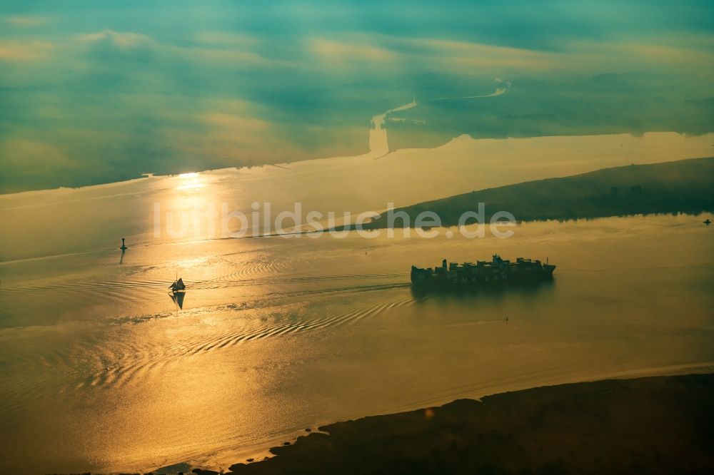 Luftbild Drochtersen - Fahrendes Containerschiff auf der Elbe im Sonnenaufgang in Drochtersen im Bundesland Niedersachsen, Deutschland