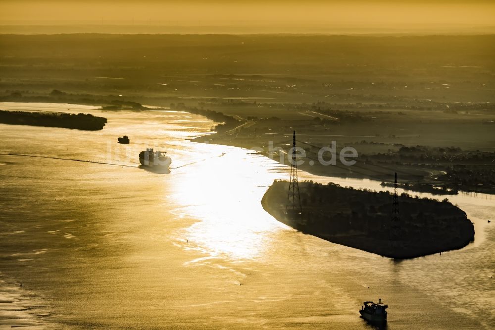 Luftaufnahme Drochtersen - Fahrendes Containerschiff auf der Elbe im Sonnenaufgang in Drochtersen im Bundesland Niedersachsen, Deutschland