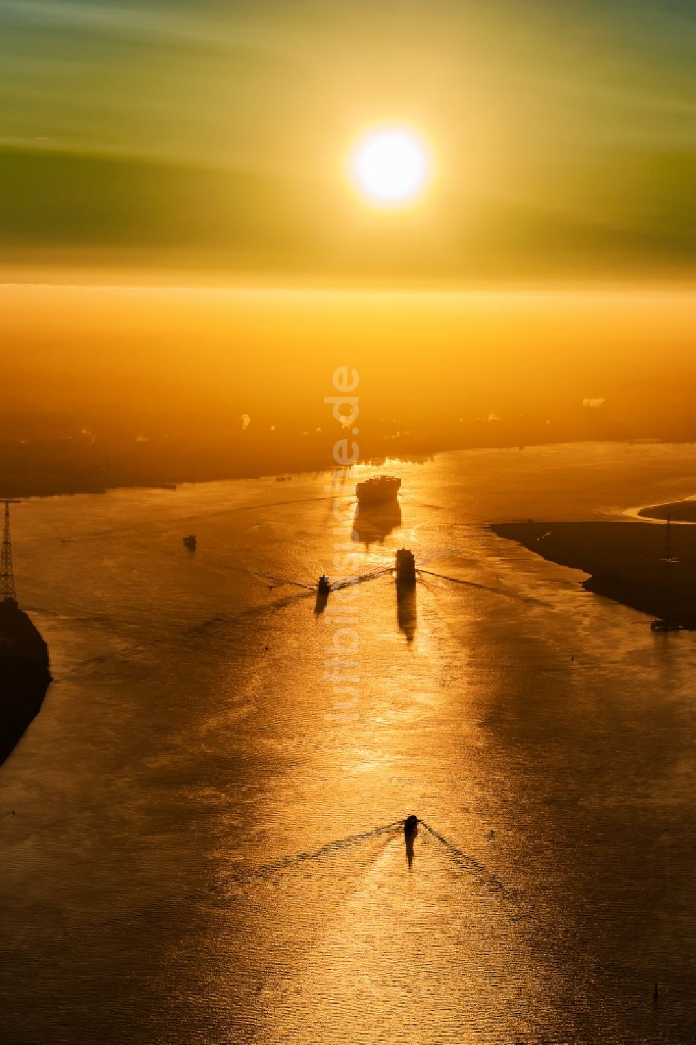 Drochtersen aus der Vogelperspektive: Fahrendes Containerschiff auf der Elbe im Sonnenaufgang in Drochtersen im Bundesland Niedersachsen, Deutschland