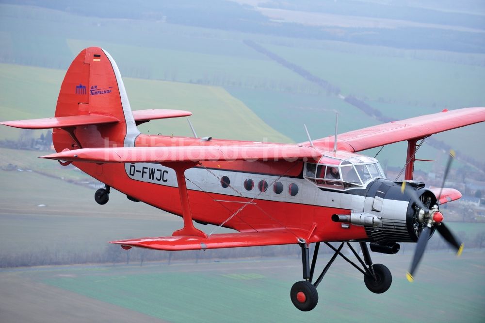 Melchow aus der Vogelperspektive: Flugzeug Antonow AN-2 mit der Kennung D-FWJC im Fluge über dem Luftraum in Melchow im Bundesland Brandenburg, Deutschland