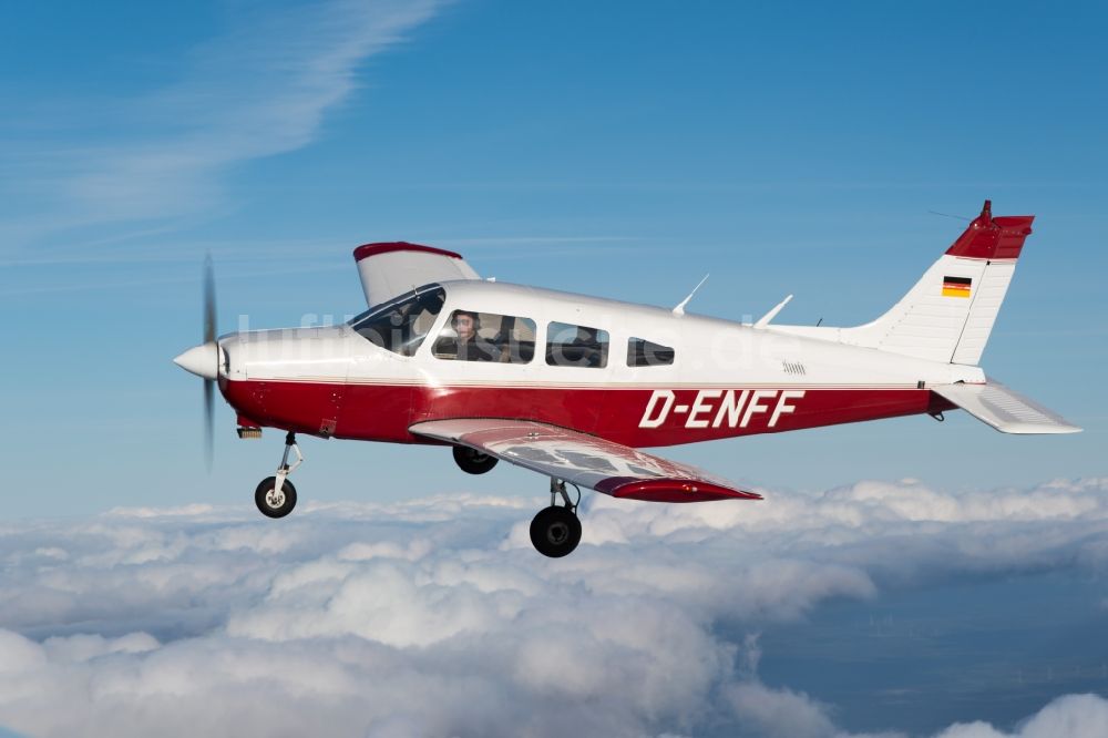 Gnarrenburg aus der Vogelperspektive: Flugzeug Piper Pa28 D-ENFF im Fluge über den Wolken bei Gnarrenburg im Bundesland Niedersachsen, Deutschland