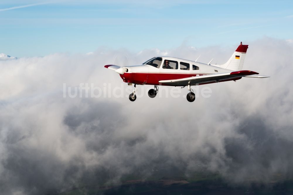 Luftaufnahme Gnarrenburg - Flugzeug Piper Pa28 D-ENFF im Fluge über den Wolken bei Gnarrenburg im Bundesland Niedersachsen, Deutschland