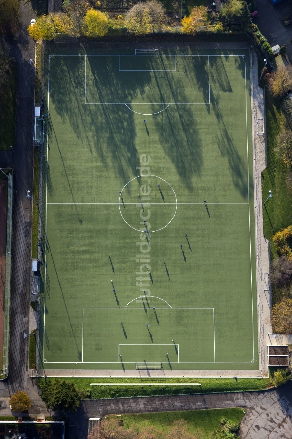 Mülheim an der Ruhr aus der Vogelperspektive: Fußball- Spieler auf dem Kunstrasen- Fußballplatz werfen lange Schatten an einem sonnigen Herbst- Tag in Mülheim an der Ruhr im Bundesland Nordrhein-Westfalen NRW