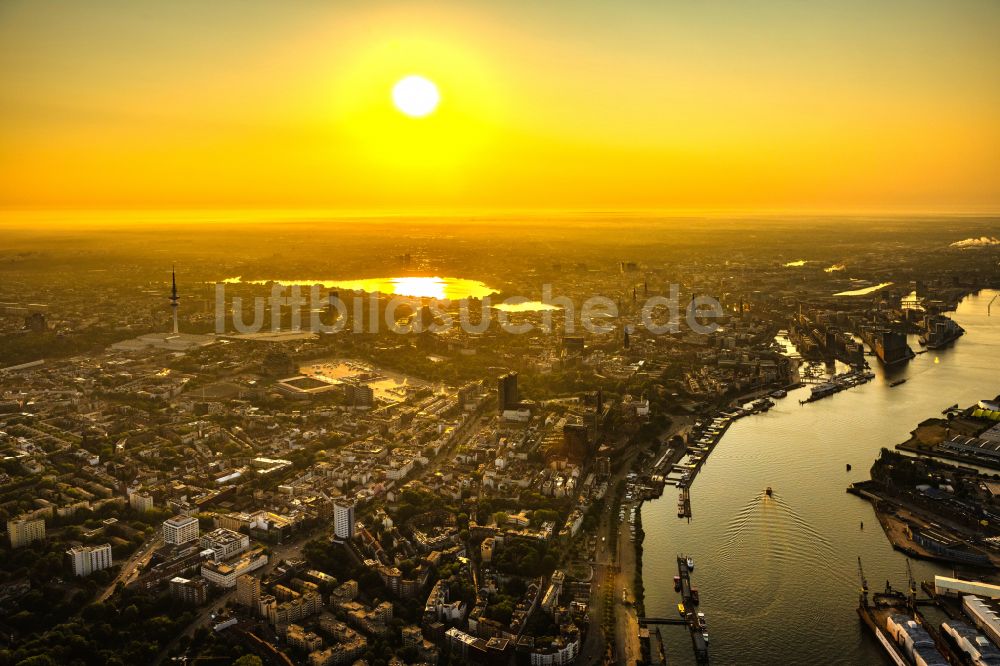 Luftaufnahme Hamburg - Hafenanlagen Landungsbrücken im Sonnenaufgang am Ufer des Flußverlaufes der Elbe in Hamburg