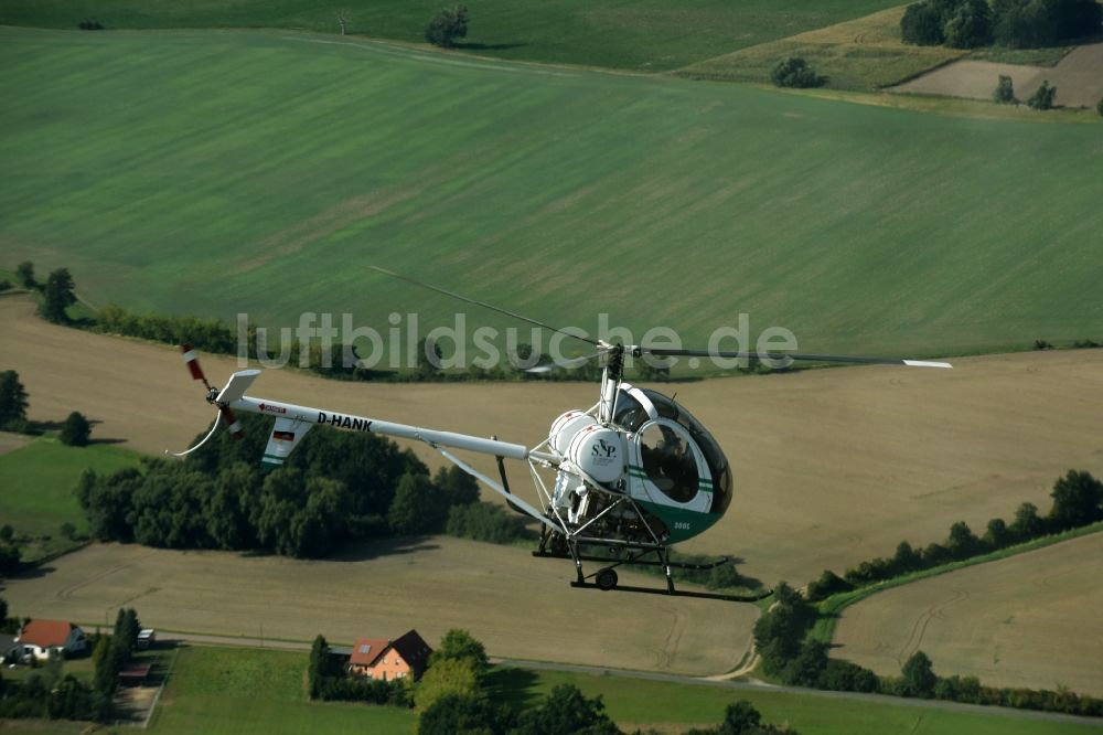 Riesigk aus der Vogelperspektive: Helikopter - Hubschrauber Hughes 300 - Schweizer 300C mit der Kennung D-HANK im Fluge über dem Luftraum in Riesigk im Bundesland Sachsen-Anhalt