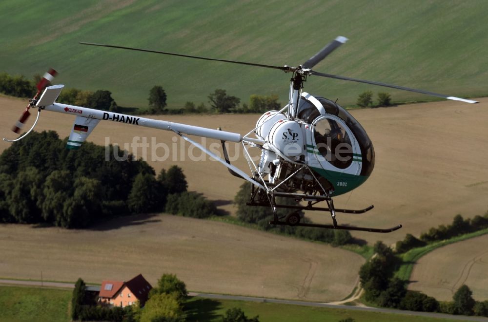 Luftbild Riesigk - Helikopter - Hubschrauber Hughes 300 - Schweizer 300C mit der Kennung D-HANK im Fluge über dem Luftraum in Riesigk im Bundesland Sachsen-Anhalt