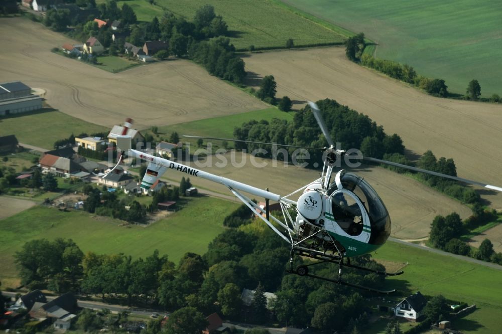 Riesigk von oben - Helikopter - Hubschrauber Hughes 300 - Schweizer 300C mit der Kennung D-HANK im Fluge über dem Luftraum in Riesigk im Bundesland Sachsen-Anhalt