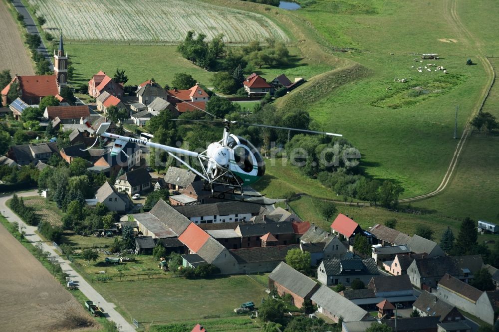 Riesigk von oben - Helikopter - Hubschrauber Hughes 300 - Schweizer 300C mit der Kennung D-HANK im Fluge über dem Luftraum in Riesigk im Bundesland Sachsen-Anhalt