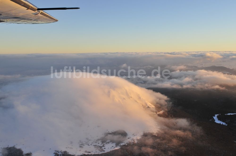 Luftaufnahme Puy de Dome - Im Sonnenuntergang mit Hochnebel verhüllter Vulkan Berg Puy-de-Dome mit aus dem Nebel ragender Sende- Antenne und dem Temple de Mercure in der Provinz Auvergne in Frankreich