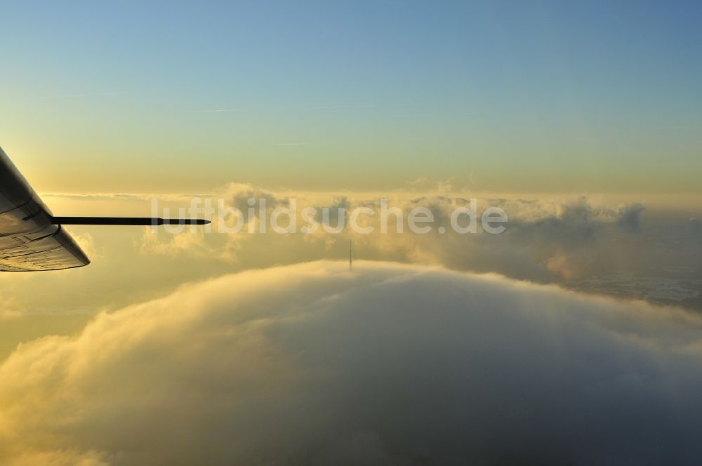 Puy de Dome von oben - Im Sonnenuntergang mit Hochnebel verhüllter Vulkan Berg Puy-de-Dome mit aus dem Nebel ragender Sende- Antenne und dem Temple de Mercure in der Provinz Auvergne in Frankreich