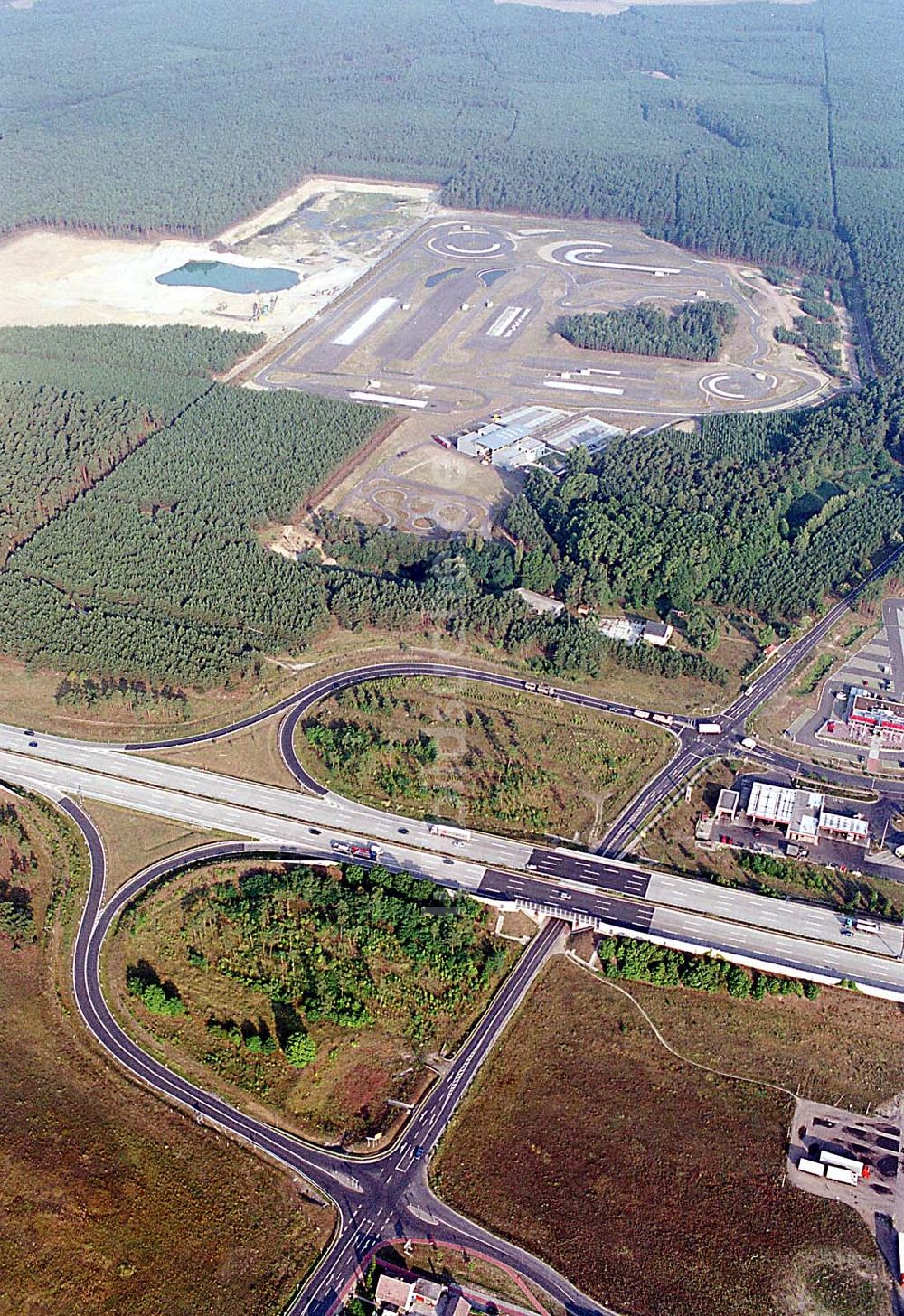 Linthe / Brandenburg aus der Vogelperspektive: Linthe / Brandenburg Blick auf eine Kiesgrube, Autoteststrecke und Autobahn A9 mit Autobahnzubringer (nach Brück) bei Linthe in Brandenburg