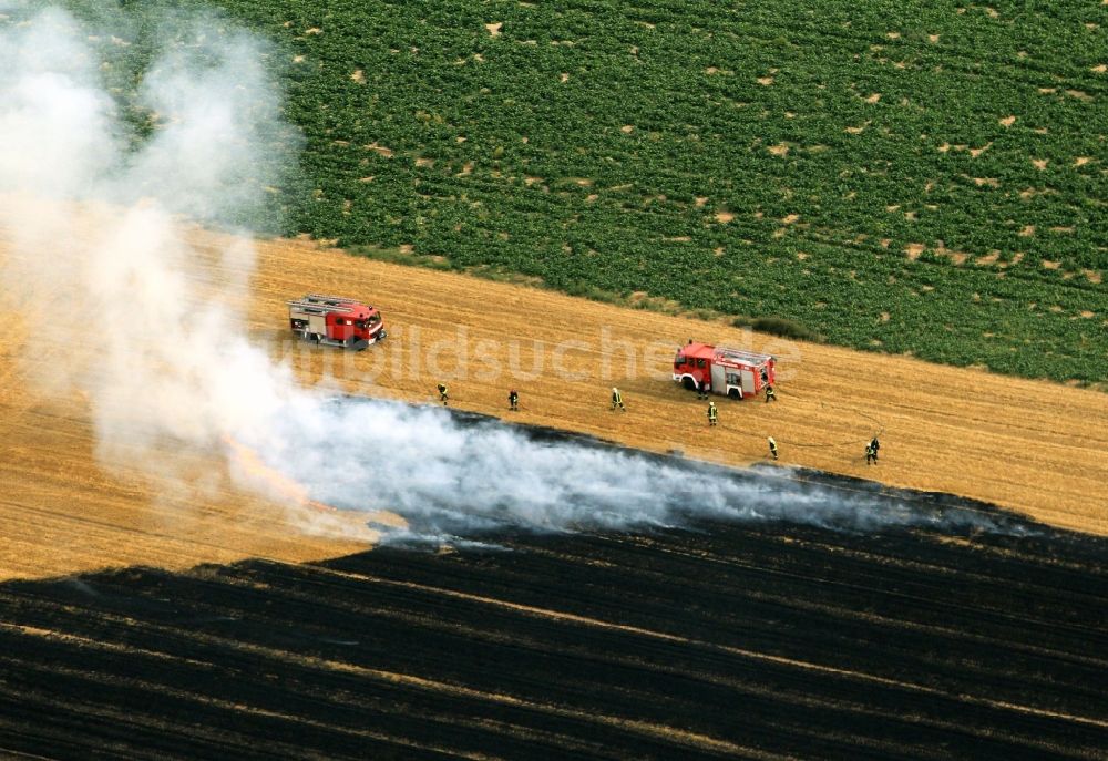 Luftaufnahme Volkenroda - Löscharbeiten der Feuerwehr auf einem kontrollierten Feld - Brand auf einem landwirtschaftlichen Gut bei Volkenroda in Thüringen