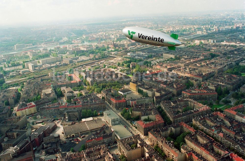 Berlin von oben - Luftschiff / Zeppelin mit der Werbeschrift der Vereinte Versicherung über dem Stadtbezirk Berlin-Friedrichshain