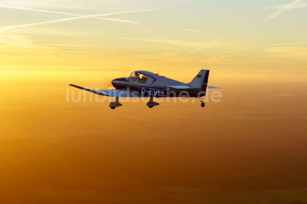 Bremervörde aus der Vogelperspektive: Motorflugzeug DR250 / 160 D-EVLL im Fluge während des Sonnenunterganges über dem Luftraum in Bremervörde im Bundesland Niedersachsen, Deutschland