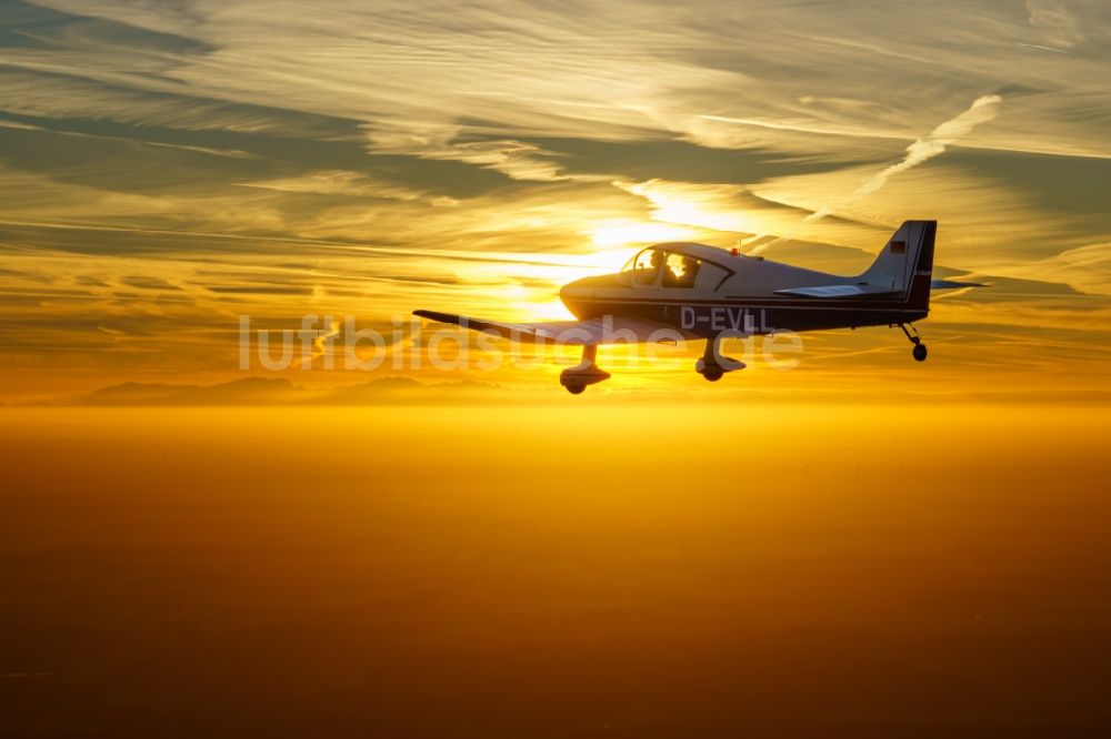 Bremervörde aus der Vogelperspektive: Motorflugzeug DR250 / 160 D-EVLL im Fluge während des Sonnenunterganges über dem Luftraum in Bremervörde im Bundesland Niedersachsen, Deutschland