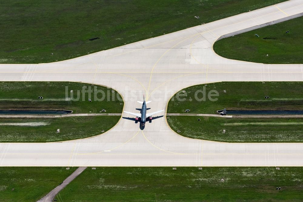 München-Flughafen von oben - Passagierflugzeug beim Rollen auf dem Rollfeld und Vorfeld des Flughafen in München-Flughafen im Bundesland Bayern, Deutschland