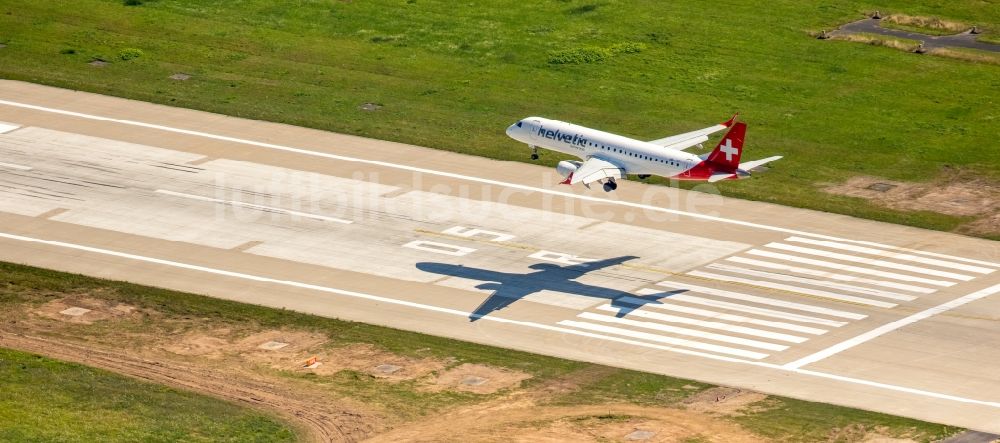 Düsseldorf von oben - Passagierflugzeug der helvetic airways über der Start- und Landebahn des Flughafens in Düsseldorf im Bundesland Nordrhein-Westfalen