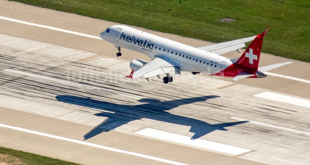 Düsseldorf von oben - Passagierflugzeug der helvetic airways über der Start- und Landebahn des Flughafens in Düsseldorf im Bundesland Nordrhein-Westfalen