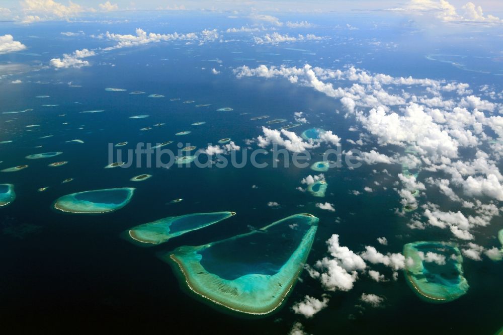 Luftaufnahme Dharanboodhoo - Quell- Wolken verhangener Küstenbereich Indischer Ozean - Insel in Dharanboodhoo in Central Province, Malediven