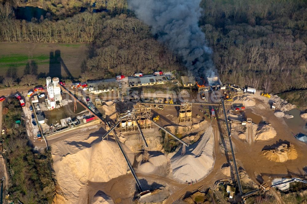 Pulheim von oben - Rauch- und Flammenbildung während der Löscharbeiten zum Brand einer Lagerhalle des Terra Kieswerkes am Ufer des Pullheimer See in Pulheim im Bundesland Nordrhein-Westfalen