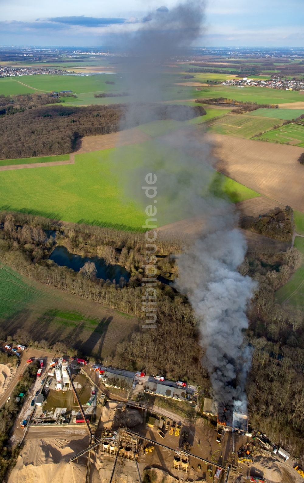 Luftbild Pulheim - Rauch- und Flammenbildung während der Löscharbeiten zum Brand einer Lagerhalle des Terra Kieswerkes am Ufer des Pullheimer See in Pulheim im Bundesland Nordrhein-Westfalen